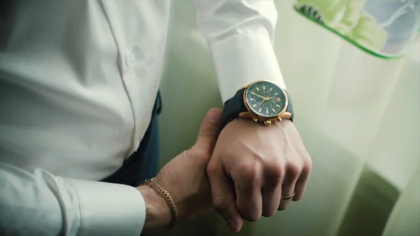 Primer plano reloj de diseño en la mano del hombre de negocios. Clip. Mano de hombre de negocios con un reloj —  Fotos de Stock