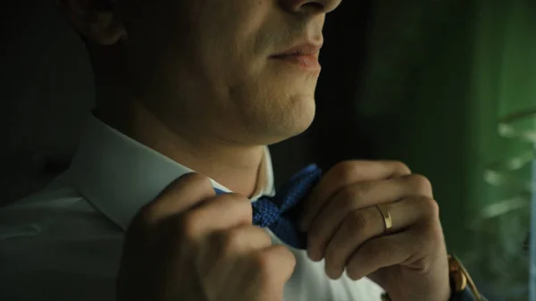 Hombre ajustando pajarita. Clip. Primer plano del joven con camisa blanca ajustando su corbata mientras está de pie —  Fotos de Stock