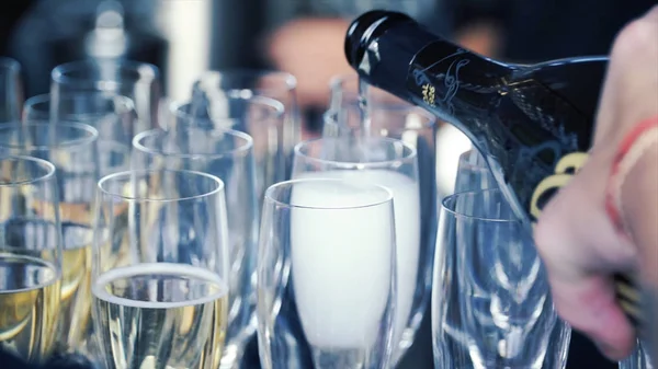 Gieten champagne in een glazen op tafel staan. Clip. Champagne wordt gegoten in glazen — Stockfoto