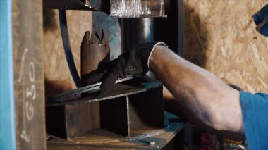 Döküm parçalarının tekerlekli otomobil fabrikasında basın tarafından. Küçük. İşçi aracı komut verme ve boşlukları basın altında el ile değiştirme