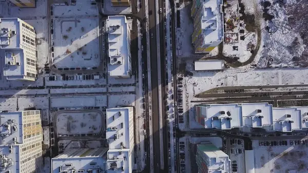 Luchtfoto sneeuw bedekte weg met de auto in de winter. Clip. Luchtfoto uitzicht over de stad in winterdag. City panorama met rechte weg van een vogel-eye view met sneeuw bedekt. De straten van de stad van de winter van een oog van de vogel — Stockfoto