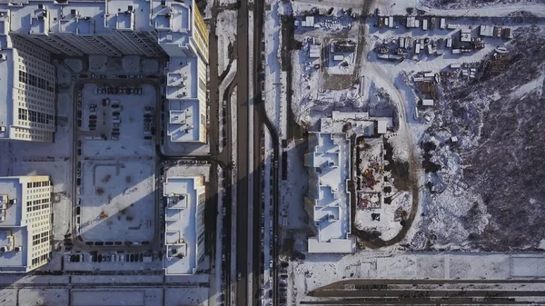 Luchtfoto sneeuw bedekte weg met de auto in de winter. Clip. Luchtfoto uitzicht over de stad in winterdag. City panorama met rechte weg van een vogel-eye view met sneeuw bedekt. De straten van de stad van de winter van een oog van de vogel — Stockfoto