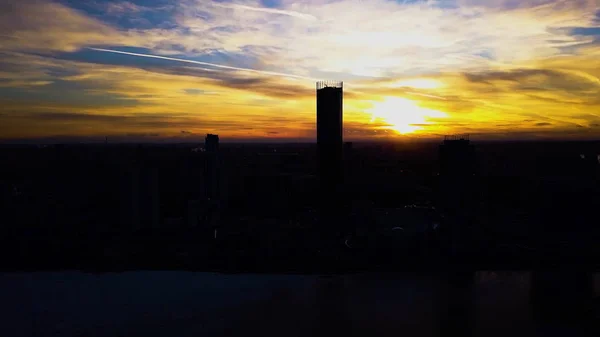 Vista aerea sul bellissimo cielo colorato tramonto drammatico sulla silhouette della città. Clip. Silhouette della città al tramonto con sfondo grattacieli. Tramonto in città con i centri commerciali di sfondo — Foto Stock