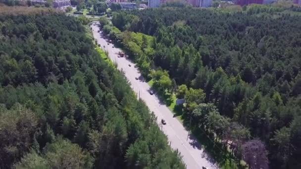 Veduta aerea della strada nella bellissima foresta autunnale al tramonto. Bellissimo paesaggio con strada rurale vuota, alberi con foglie verdi, rosse e arancioni. Autostrada attraverso il parco. Vista dall'alto dal drone volante. Clip — Video Stock