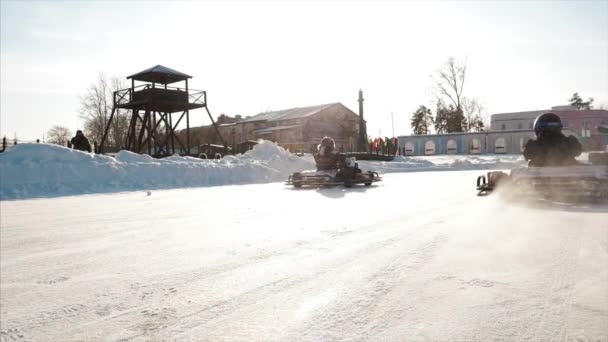 Winter karting concurrentie op het spoor van ijs. Clip. Motie van go kart race in de winter — Stockvideo