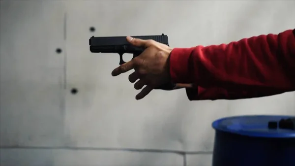 Gun is shot close-up. Pistol in hand close-up. Pistol being shot 1 times. Man shoots a black gun