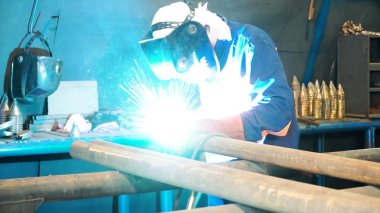 MIG kaynak tarafından inşaat kaynak işçisi. Küçük. Alt kılavuz tarafından ara çelik parça