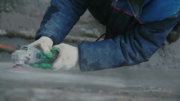 Trabalhador construtor com moedor máquina de corte acabamento parede de concreto no canteiro de obras. Clipe. Trabalhador moagem parede de concreto — Vídeo de Stock