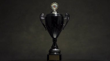 Şampiyon Altın Kupa koyu arka plan kopya alanı ile ahşap masa senin tasarım kazanmak için hazır yerleştirilir. Natürmort resim Trophy stüdyoda vurdu. ahşap masa üzerinde şampiyonu Altın Kupa