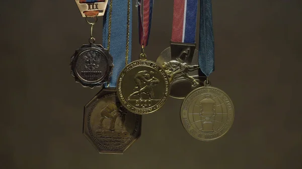 Close up of the golden medals. A rugged gold medal setup majestically against grey background. Gold medals before handing to champions. Gold, silver and bronze medals close up