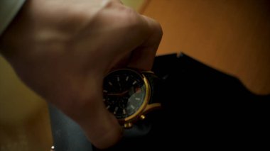 Kol saati yakın kadar çekici bir adam. Küçük. Adam masaya geliyor ve kol saati alır. Bir adam bir kol saati masanın üzerine alır.