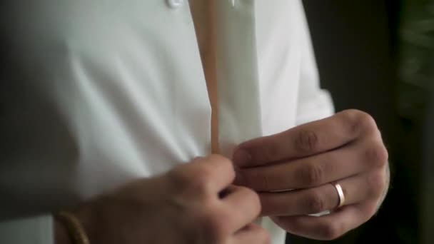 Close up van zakenman draagt een wit overhemd. Clip. Close-up van man verkleden en wit overhemd met Manchetknopen aan te passen. De man in het witte shirt in de venster jurk Manchetknopen. — Stockvideo