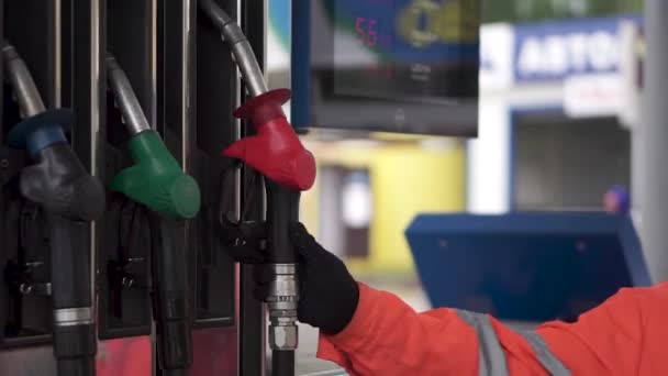 Oil, fuel nozzles hang on the machine in the petrol station. Clip. Close-up of a mens hand using a fuel nozzle at a gas station. Petrol station. Filling station. Petrol. Gasoline. Man holding a — Stock Video