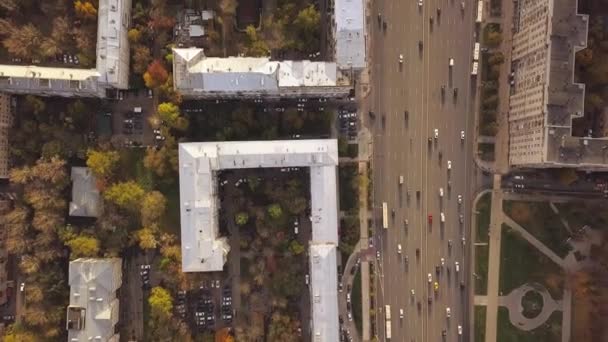 Luchtfoto Stadszicht met kruispunt, wegen, huizen, gebouwen, parken en parkeerterreinen. Clip. Bovenaanzicht van de brede weg in de stad — Stockvideo