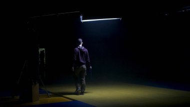 Film ekibi bir Videoclip oluşturulması üzerinde çalışıyor. Gaffer stüdyoda bir ışık için difüzyon hazırlar. Gaffer video üretim seti üzerinde bir Fresnel ışık mavi jel koyar