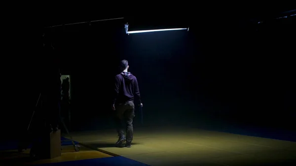Ekipa filmowa pracuje nad stworzeniem Videoclip. Gaffer przygotowuje dyfuzję dla światła w studiu. Gaffer stawia niebieski żel na świetle Fresnela na zestawie do produkcji wideo — Zdjęcie stockowe
