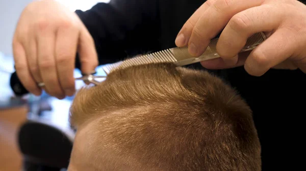 Primo piano di mens taglio di capelli forbici in un salone di bellezza. Master taglia i capelli e la barba degli uomini nel barbiere, parrucchiere fa acconciatura per un giovane uomo. Primo piano di Man al Salone da parrucchiere — Foto Stock