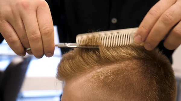 Primer plano de las tijeras de corte de pelo para hombre en un salón de belleza. Master corta el pelo y la barba de los hombres en la peluquería, peluquería hace peinado para un hombre joven. Primer plano del hombre en la peluquería —  Fotos de Stock