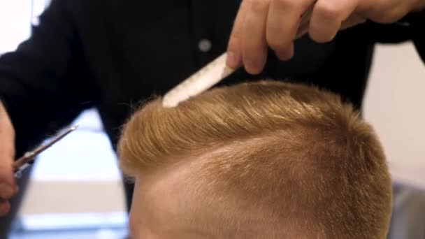 Close up of mens hair cutting scissors in a beauty salon. Master cuts hair and beard of men in the barbershop, hairdresser makes hairstyle for a young man. Close up of Man at the Hair salon — Stock Video