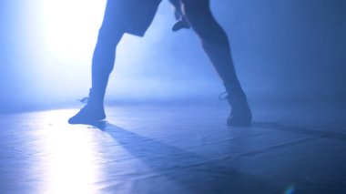 Alt görünümü Fighter duman ve ışık arka plan ile spor salonunda eğitim. Koyu arka plan üzerinde güçlü erkek boxer silüeti. Atlet veya sporcu antrenman yaparken hızlı hareket yakın çekim