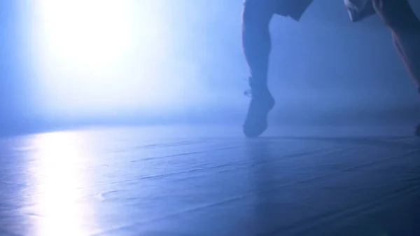 Κάτω άποψη της κατάρτισης στο γυμναστήριο με φόντο καπνού και ελαφρύ μαχητικό. Σιλουέτα του ισχυρό αρσενικό μπόξερ σε σκούρο φόντο. Κοντινό πλάνο του αθλητή ή αθλητή που κινείται γρήγορα, ενώ κατάρτισης — Φωτογραφία Αρχείου