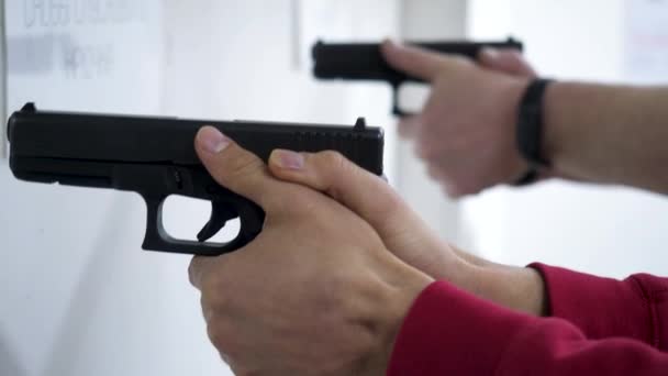 Instructor teaches a man to handle a weapon or gun. Close up of male hands with gun while training with instructor. Close up of mans hand reloading gun — Stock Video