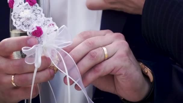 Zblízka se mužské ruky s snubní prsten držení šumivé šampaňské na svatební obřad v letní přírodě pozadí. Kavkazské muž, který držel sklenku šampaňského. Muž, který držel sklenku — Stock video