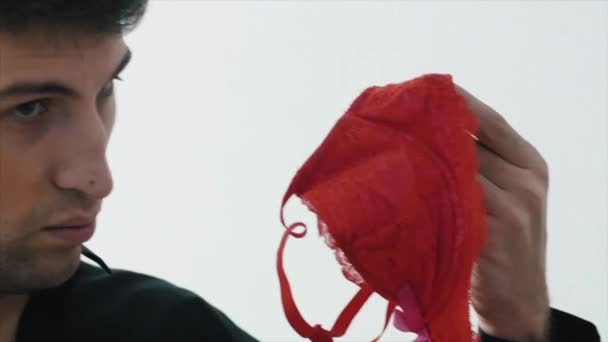 Man puts a red bra in a box. The concept of cleaning. Man cleans things in a box — Stock Video