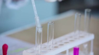 4 in 1. Bir laboratuvar cam tüp kimyasal bir çözümden bir deneyde bilim araştırma laboratuvarı için sıvı ile bilimsel bir silindir içine dökme bilim adamı eliyle footages kümesi