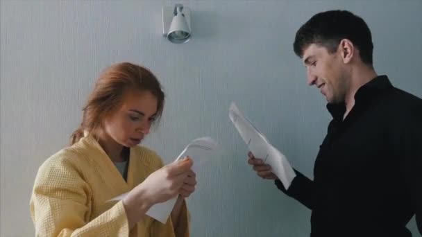 Casal está lendo um contrato de casamento em casa. Documento de contrato bancário de leitura de casal. Casal de família ocupado lê termos contratuais antes de cantar contrato, calcular o total de dívidas do empréstimo — Vídeo de Stock