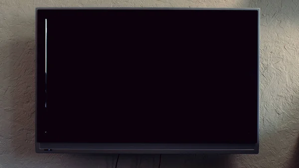 Телевизор на стене. Led tv on the wall fon with blank television screen. ЖК или светодиодный телевизор висит на стене с вырезкой пути — стоковое фото