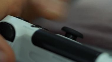Evde bir video oyunları oynarken bir joystick denetleyicisi tutan erkek el kapatın. Gamepad tutarak ve oyun oynamayı kişi yakın çekim.