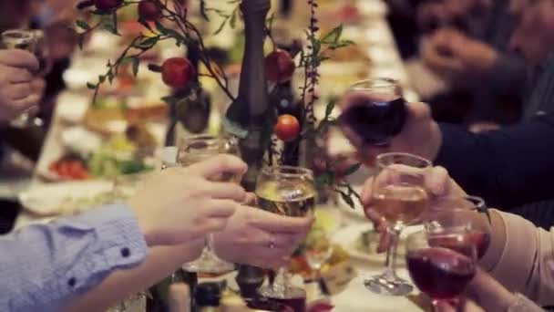 Manos sosteniendo vasos y tostadas, feliz momento festivo, concepto de celebración de lujo. Tiro de vasos en la mesa festiva. La gente rechina vasos juntos. Brindis con copas de lujo — Vídeo de stock