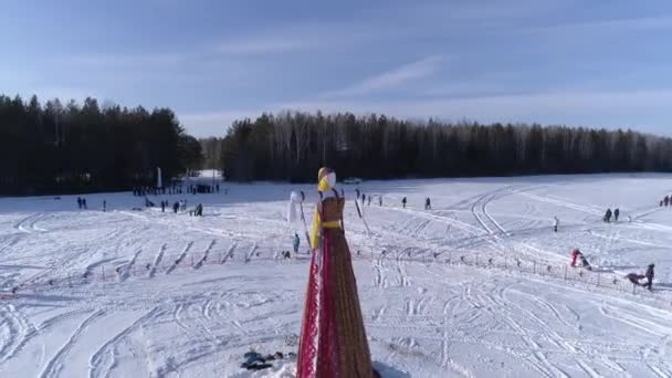Muitas pessoas olham a queimadura do manequim durante a celebração de férias tradicionais russas Maslenitsa à tarde de inverno. Filmagem. Vista aérea — Vídeo de Stock