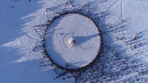 Krąg osób, które oglądać spalanie manekina podczas uroczystości rosyjski tradycyjne święto Maślenica. Materiał filmowy. Widok z lotu ptaka — Wideo stockowe