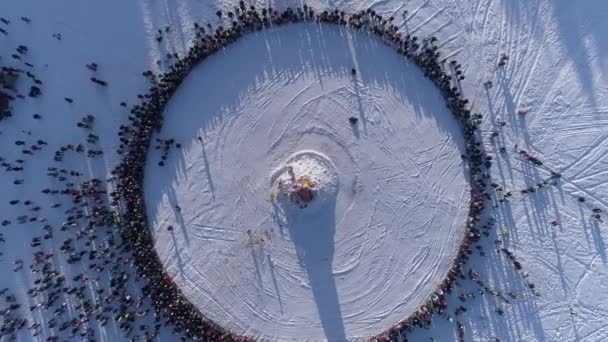 Círculo de personas que ven la quema de maniquí durante la celebración de la fiesta tradicional rusa Maslenitsa. Filmación. Vista aérea — Vídeos de Stock