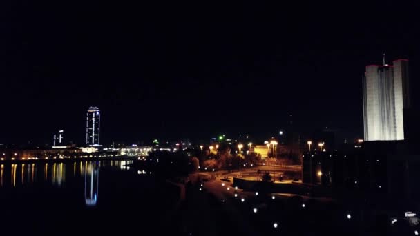 Vista aérea de la noche de ciudad. Camino de asfalto vacío e iluminado moderno paisaje urbano de fondo por la noche. Construyendo ciudad vista superior abstracta — Vídeo de stock