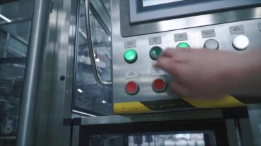 Fabrika işçisi presler düğmesine denetim noktası olarak ve üretim hattı, ilk kişi görünümü konveyör başlar. Küçük. Bilgisayar kontrollü üretim hattı. Modern gıda fabrikası. Otomatik taşıyıcı