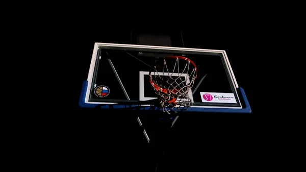 Крупным планом баскетбольный мяч проходит через сетку для полевого гола. Крупный план баскетболиста, бегущего вверх и бросающего мяч. Крупный план баскетболиста, делающего бросок в баскетбол — стоковое фото