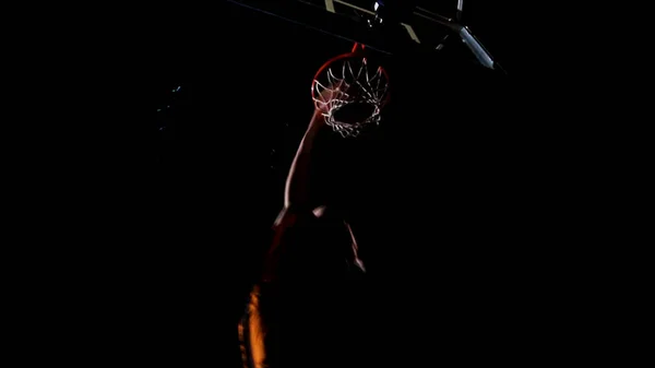 Primer plano de una canasta de baloncesto. Lanzar un aro de baloncesto en el fondo de focos amarillos, la pelota golpea el anillo es lo que vuela a través de la red. Baloncesto en aro, cámara lenta — Foto de Stock