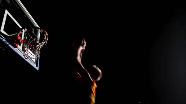 Close up van een basketbal gaan door het net voor een field goal. A close up van een basketbal-speler aangelopen en dunking de bal. Close up van basketbalspeler maken slam dunk in het basketbalspel — Stockfoto