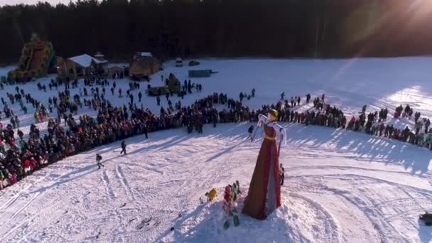 Москва, Россия - 26 февраля 2018 года: Воздушный вид на традиционное сжигание Масленицкого пугала. Сжигание Пугало. Празднование Асленицы. Человек поджигает большую куклу-пугало на сцене в городе — стоковое видео