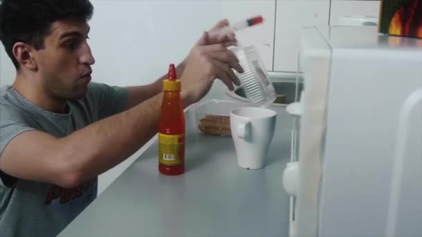 Adam acı sos bozmak yemek için ekler. Mutfakta, bir adam şaka çanak baharatlı sos ganimet — Stok video