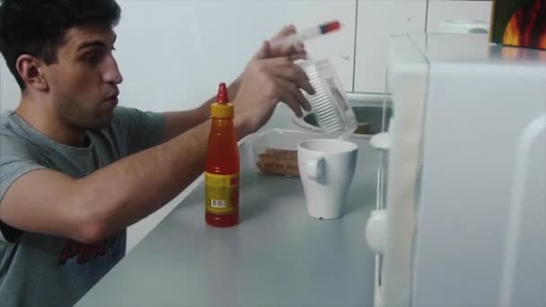 O homem adiciona molho picante ao prato para estragá-lo. Piada na cozinha, um homem estraga o prato molho picante — Vídeo de Stock