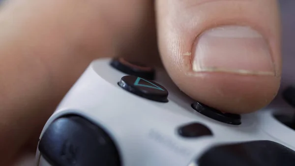 Închiderea mâinilor de sex masculin ținând un controler joystick în timp ce jucați jocuri video acasă - Tineri care se distrează cu jocuri - Gaming, divertisment, concept tehnologic . — Fotografie, imagine de stoc