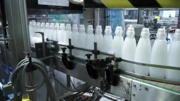 工厂和研究理念。剪辑。生产设备上有白色物质的瓶子会被扭曲。在输送带上排瓶。生产流程 — 图库视频影像
