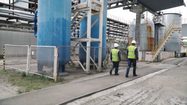 Mühendis ve ustabaşı fabrikada. Klip. Koruyucu kask fabrikasında iki işçi