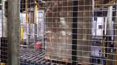 Ağır yük makinesi tarafından bir folyo ile bir palet sarma kutuları. Küçük. Ağır yük makinesi tarafından bir folyo ile bir palet sarma kutuları