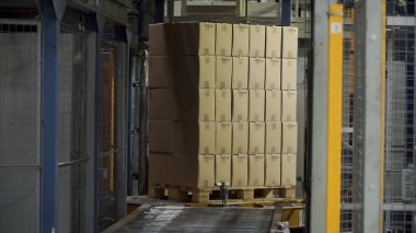 Nakliye kutusuna hareket Konveyör bant, yolun sonu. Küçük. Konveyör bant karton kutular ile çalışma alanı'ndaki koridor boyunca hareket ediyor. Bir fabrikada bir Konveyör bant üzerinde seyahat Carboard kutuları