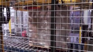Ağır yük makinesi tarafından bir folyo ile bir palet sarma kutuları. Küçük. Ağır yük makinesi tarafından bir folyo ile bir palet sarma kutuları